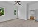 Bright bedroom featuring neutral carpet, ceiling fan, and two windows offering verdant views at 2601 Mayview Rd, Raleigh, NC 27607