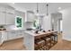 Bright kitchen featuring a large island with seating, pendant lights, sleek white cabinets, and modern fixtures at 2601 Mayview Rd, Raleigh, NC 27607