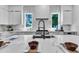 Bright kitchen featuring white cabinetry, countertops, and a sleek island with a modern faucet and stainless steel appliances at 2601 Mayview Rd, Raleigh, NC 27607