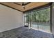 Comfortable screened-in porch with stone flooring and ceiling fan offering a serene view at 2601 Mayview Rd, Raleigh, NC 27607