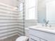 Modern bathroom featuring a glass-enclosed shower with gray and white striped tiles at 167 Edgefield St, Pittsboro, NC 27312