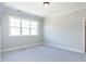 Light-filled bedroom showcasing large windows, neutral walls, and cozy carpet flooring at 167 Edgefield St, Pittsboro, NC 27312