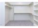 Walk in closet with carpet and white shelving with wooden rods at 167 Edgefield St, Pittsboro, NC 27312