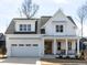 Beautiful two-story home with a white exterior, covered front porch, and attached garage at 167 Edgefield St, Pittsboro, NC 27312