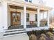 Inviting front porch with stone floor, wooden door, and a bench, offering a cozy welcome at 167 Edgefield St, Pittsboro, NC 27312