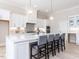 Spacious white kitchen with a large center island, pendant lighting, and bar stool seating at 167 Edgefield St, Pittsboro, NC 27312