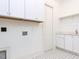 White laundry room with tile floors and cabinet storage at 167 Edgefield St, Pittsboro, NC 27312