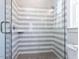 Sleek walk-in shower with gray and white striped tiles and a glass enclosure at 167 Edgefield St, Pittsboro, NC 27312