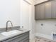 Laundry room with gray cabinets and a utility sink at 75 Ridgeline Ct, Pittsboro, NC 27312