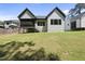 A spacious backyard with lush green grass and a view of the home's exterior, including a screened-in porch at 5307 Dixon Dr, Raleigh, NC 27609