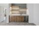 Home bar area featuring stylish cabinets, lighting, marble counters and a built-in beverage center at 5307 Dixon Dr, Raleigh, NC 27609