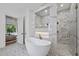 Bright bathroom featuring a soaking tub, glass shower, and modern finishes at 5307 Dixon Dr, Raleigh, NC 27609