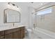 Stylish bathroom featuring warm wood cabinets, modern fixtures, and bright shower with transom window at 5307 Dixon Dr, Raleigh, NC 27609