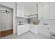 Bright laundry room with stylish tile flooring, gray backsplash, and custom white cabinetry at 5307 Dixon Dr, Raleigh, NC 27609