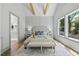 Vaulted main bedroom with wood beams, chandelier, paneled wall, and three windows at 5307 Dixon Dr, Raleigh, NC 27609