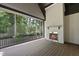 Relaxing screened-in patio featuring a cozy fireplace and natural view from the wooden deck at 5307 Dixon Dr, Raleigh, NC 27609