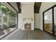 An outdoor patio with a fireplace and wood floors; interior space is visible through a sliding glass door at 5307 Dixon Dr, Raleigh, NC 27609