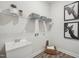 Bright laundry room featuring a utility sink, wood-look floors, and storage shelves at 2009 Abbeyhill Dr # 63, Raleigh, NC 27610