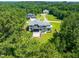 Stunning aerial view of a modern home with a sprawling lawn, surrounded by lush greenery and mature trees at 213 Westhampton Dr, Pittsboro, NC 27312