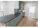 Stylish bar area boasts light green cabinets, black countertop, brass hardware, beverage fridge and tile backsplash at 213 Westhampton Dr, Pittsboro, NC 27312