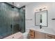The bathroom is equipped with green tile shower, matte fixtures, vanity and a framed mirror at 213 Westhampton Dr, Pittsboro, NC 27312