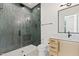 Modern bathroom with a sleek glass-enclosed shower, green tile, and a floating vanity with a white countertop at 213 Westhampton Dr, Pittsboro, NC 27312