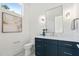 Stylish powder room featuring a navy vanity with marble countertop, sleek fixtures, and modern lighting at 213 Westhampton Dr, Pittsboro, NC 27312