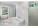 Elegant primary bathroom features a soaking tub and shower with marble tile at 213 Westhampton Dr, Pittsboro, NC 27312