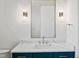 Close-up of a modern powder bath featuring designer mirror and lighting, and a floating vanity with marble countertop at 213 Westhampton Dr, Pittsboro, NC 27312