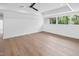 Spacious bedroom featuring hardwood floors, a ceiling fan, recessed lighting and large windows showcasing a wooded view at 213 Westhampton Dr, Pittsboro, NC 27312