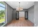 Bedroom with large windows offering scenic views and a modern chandelier at 213 Westhampton Dr, Pittsboro, NC 27312
