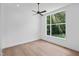 This bedroom features a large window overlooking a private backyard and ceiling fan, with hardwood floors at 213 Westhampton Dr, Pittsboro, NC 27312