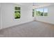 Bright bedroom with neutral carpet, a ceiling fan, and multiple windows offering wooded views at 213 Westhampton Dr, Pittsboro, NC 27312