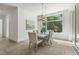 Well-lit dining room with a neutral color scheme, modern chandelier, and large window providing a view of the greenery at 213 Westhampton Dr, Pittsboro, NC 27312