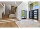 Welcoming entryway with a wood staircase, large windows, and grand black double-door entrance at 213 Westhampton Dr, Pittsboro, NC 27312
