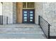 Stone steps and black metal railing lead to an impressive front door at 213 Westhampton Dr, Pittsboro, NC 27312