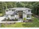 Stunning front exterior with stone accents, a modern double-door entrance, and lush, professionally landscaped yard at 213 Westhampton Dr, Pittsboro, NC 27312