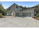 Exterior view showcasing the three-car garage with stylish glass doors and a spacious concrete driveway at 213 Westhampton Dr, Pittsboro, NC 27312