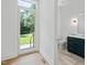 Hallway features wood floors and a view of the lawn from the back door and a modern half bathroom at 213 Westhampton Dr, Pittsboro, NC 27312