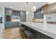 Modern kitchen with large marble island, wine cooler, stainless appliances and stylish cabinets and fixtures at 213 Westhampton Dr, Pittsboro, NC 27312