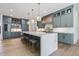 Modern kitchen showcasing a large island with marble countertops, stylish cabinets and fixtures, and pendant lighting at 213 Westhampton Dr, Pittsboro, NC 27312