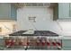 A high-end stainless steel range with a pot filler and gray marble backsplash is featured in this gourmet kitchen at 213 Westhampton Dr, Pittsboro, NC 27312