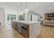 Open concept kitchen island with marble countertops, a microwave, sink, and modern pendant lighting at 213 Westhampton Dr, Pittsboro, NC 27312