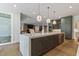 Kitchen with a marble countertop island, integrated stainless steel appliances, and hardwood floors throughout the open floor plan at 213 Westhampton Dr, Pittsboro, NC 27312