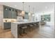 The kitchen features a large island with marble countertops, pendant lighting, and stylish cabinetry with backyard view from window at 213 Westhampton Dr, Pittsboro, NC 27312