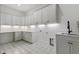 Well-lit laundry room with ample storage cabinets and counter space, plus patterned tile floor at 213 Westhampton Dr, Pittsboro, NC 27312