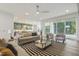 Spacious living room with modern furnishings, fireplace, fan, and an open concept to the adjacent kitchen at 213 Westhampton Dr, Pittsboro, NC 27312