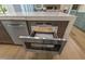 Stainless steel microwave built into the kitchen island cabinetry with a pull-out drawer design and digital display at 213 Westhampton Dr, Pittsboro, NC 27312