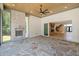 Covered patio with stone floor, fireplace, ceiling fan, and access to interior and backyard at 213 Westhampton Dr, Pittsboro, NC 27312