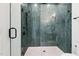 Close-up of a modern glass shower featuring stylish green vertical tiles and black fixtures at 213 Westhampton Dr, Pittsboro, NC 27312